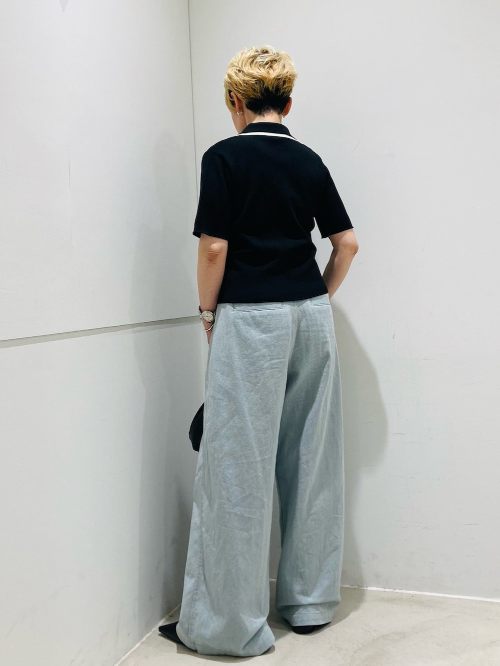 ブラック系のニット/セーター、ブラック系のパンプス、ブルー系のデニムパンツを着用したレディースの春コーディネートの3枚目の写真