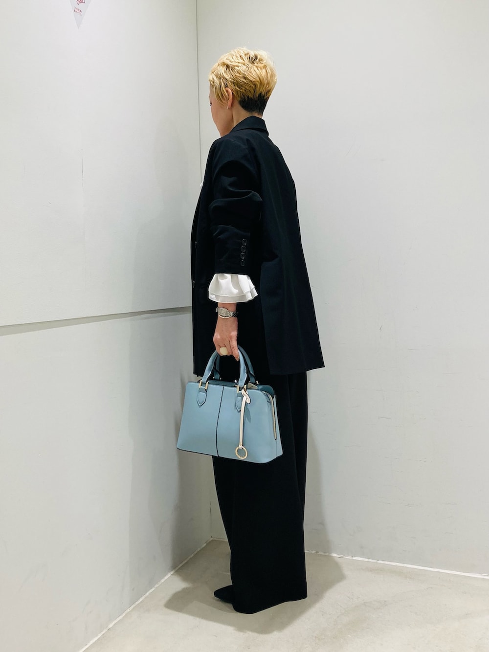 ブラック系のテーラードジャケット、ホワイト系のシャツ/ブラウス、ブラック系のスラックスを着用したレディースの春コーディネートの2枚目の写真