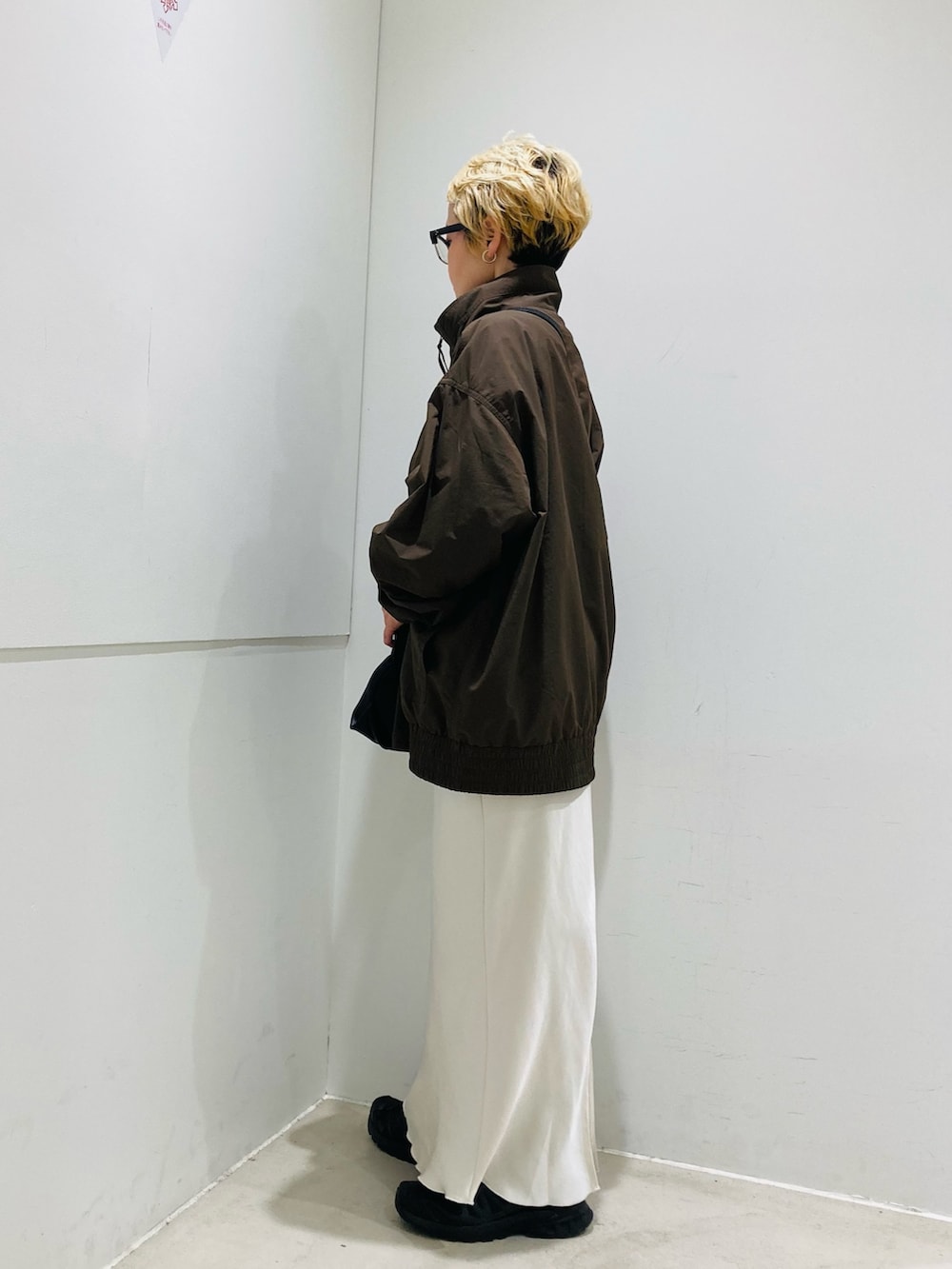 ブラック系のショルダーバッグ、ブラウン系のブルゾン、ブラウン系のTシャツ/カットソーを着用したレディースの春コーディネートの3枚目の写真