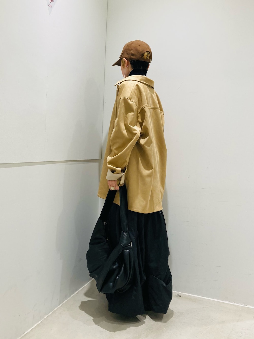 ベージュ系のその他アウター、グレー系のスカート、ブラック系のショルダーバッグを着用したレディースの冬コーディネートの2枚目の写真