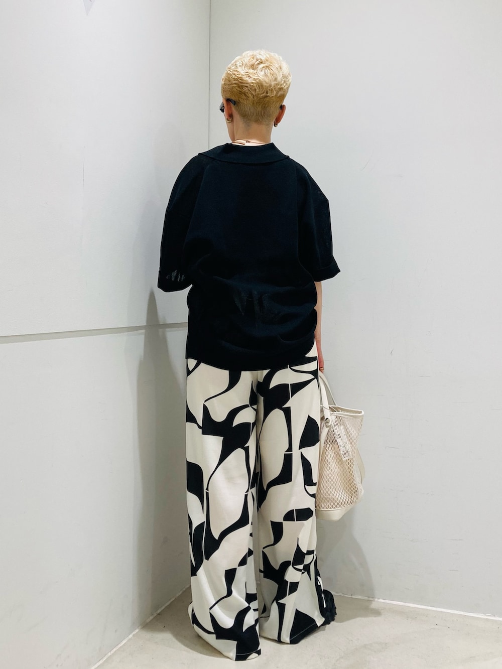 ブラック系のニット/セーター、ブラック系のその他パンツ、ホワイト系のトートバッグを着用したレディースの夏コーディネートの3枚目の写真