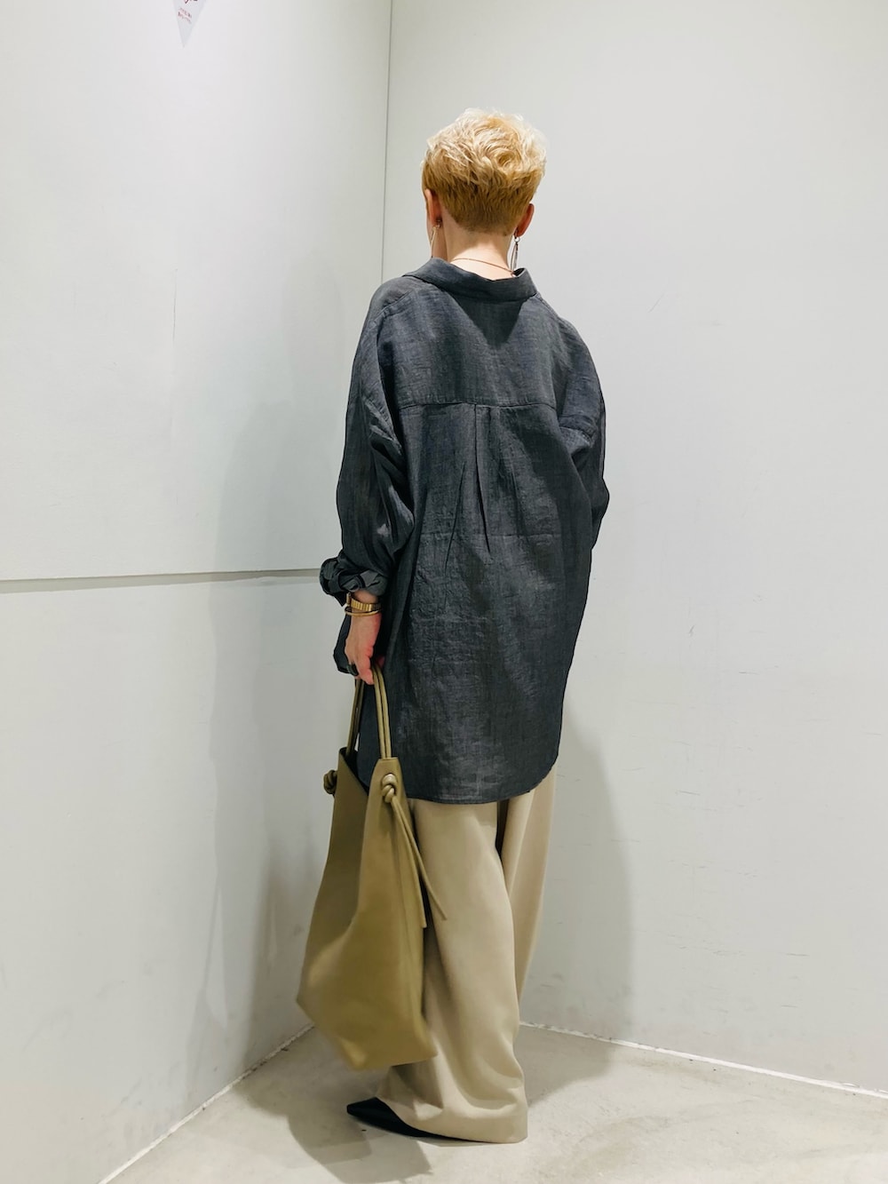 ブラック系のシャツ/ブラウス、ベージュ系のスラックス、ブラック系のパンプスを着用したレディースの春コーディネートの2枚目の写真