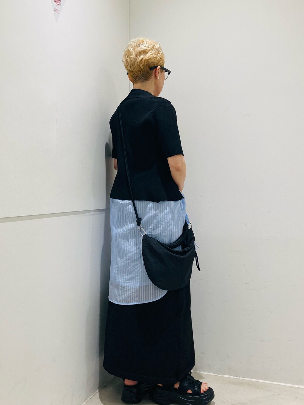 ブルー系のシャツ/ブラウス、ブラック系のサンダル、ブラック系のハンドバッグを着用したレディースの春コーディネートの3枚目の写真