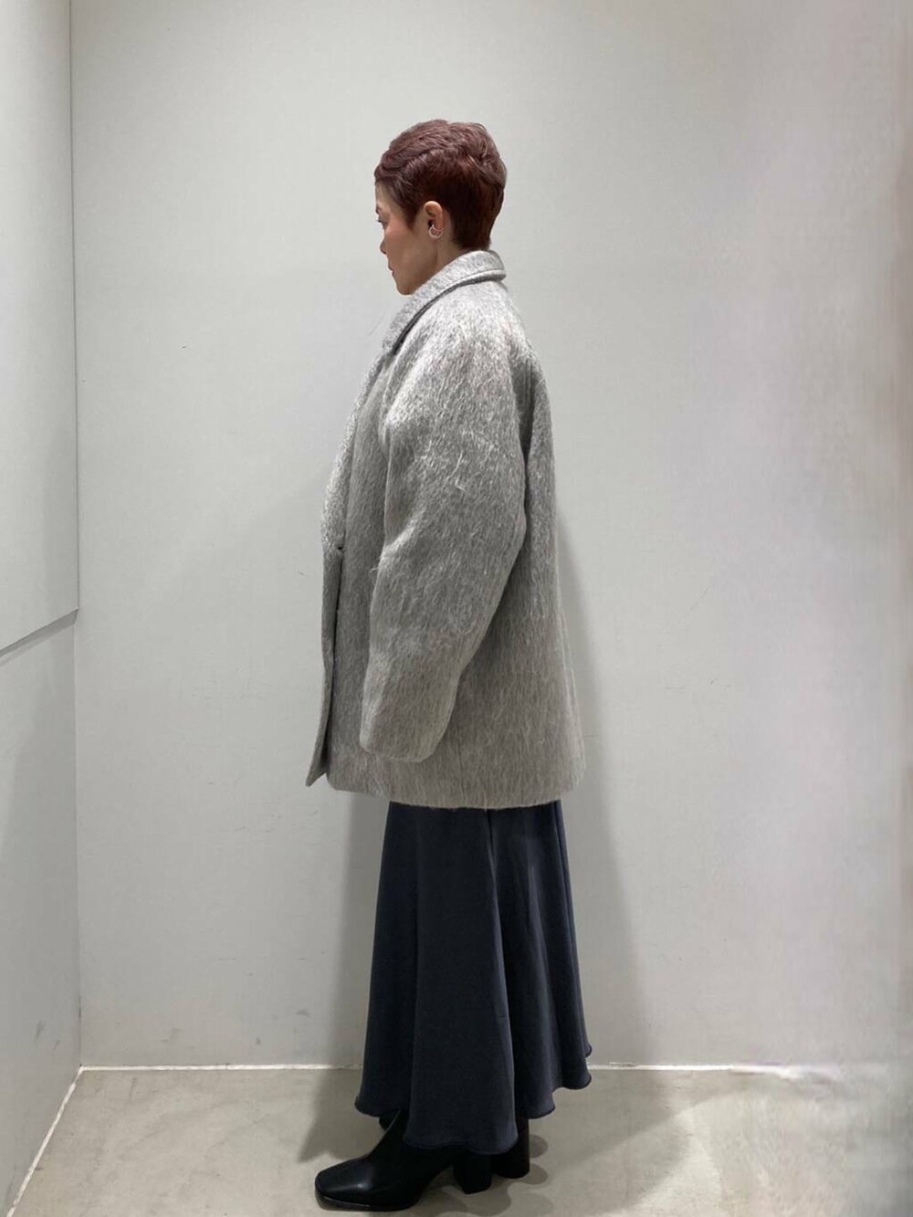 ブラック系のブーツ、グレー系のスカート、ホワイト系のTシャツ/カットソーを着用したレディースの冬コーディネートの2枚目の写真