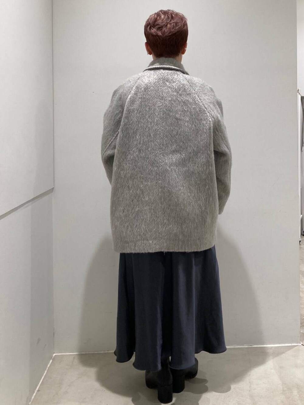 ブラック系のブーツ、グレー系のスカート、ホワイト系のTシャツ/カットソーを着用したレディースの冬コーディネートの3枚目の写真