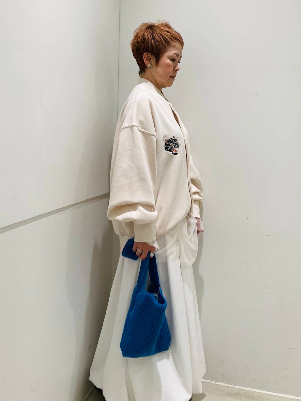 ホワイト系のスカート、ホワイト系のTシャツ/カットソー、ホワイト系のブルゾンを着用したレディースの冬コーディネートの2枚目の写真