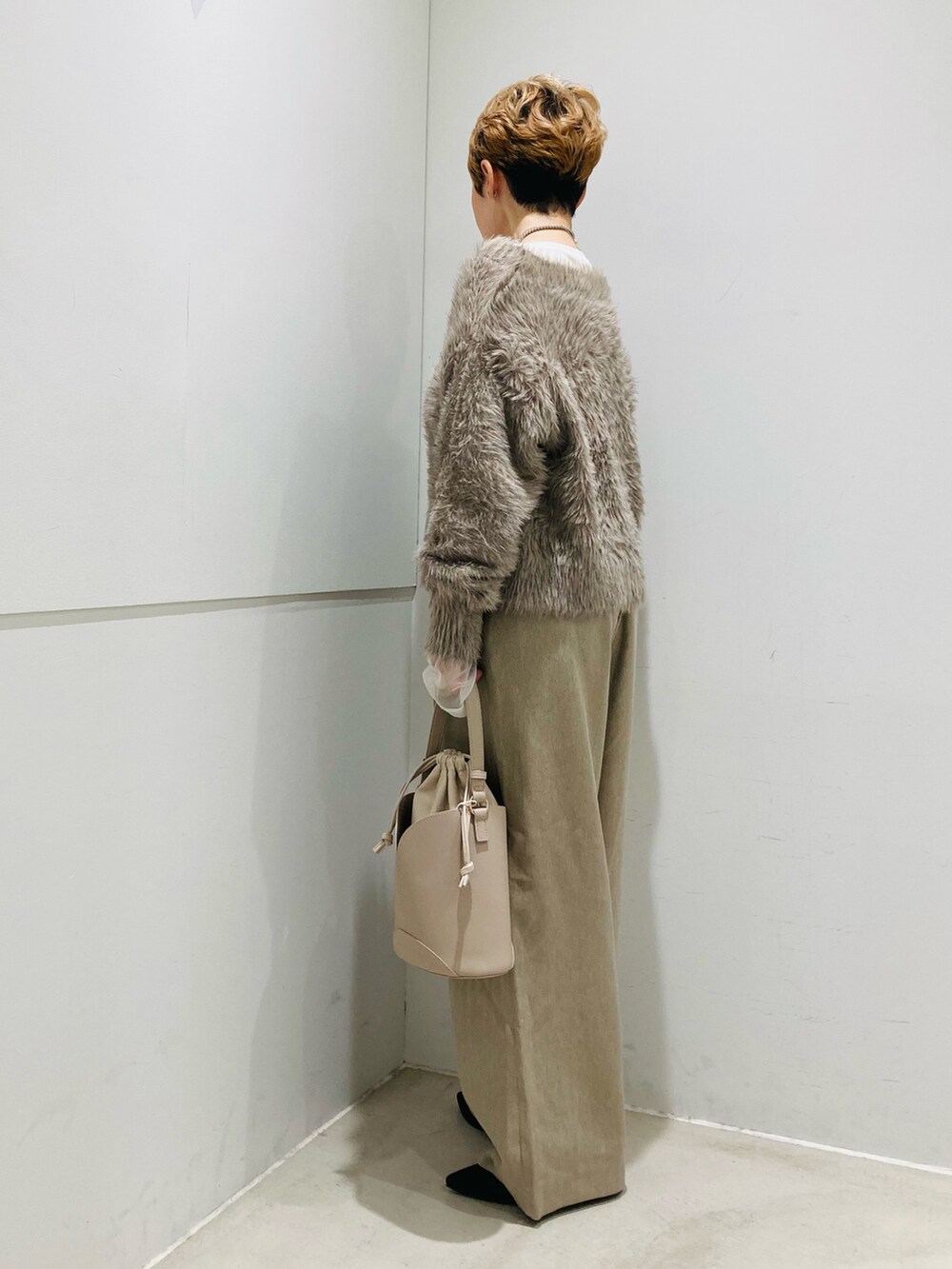 ベージュ系のニット/セーター、ベージュ系のハンドバッグ、ベージュ系のその他パンツを着用したレディースの秋コーディネートの2枚目の写真