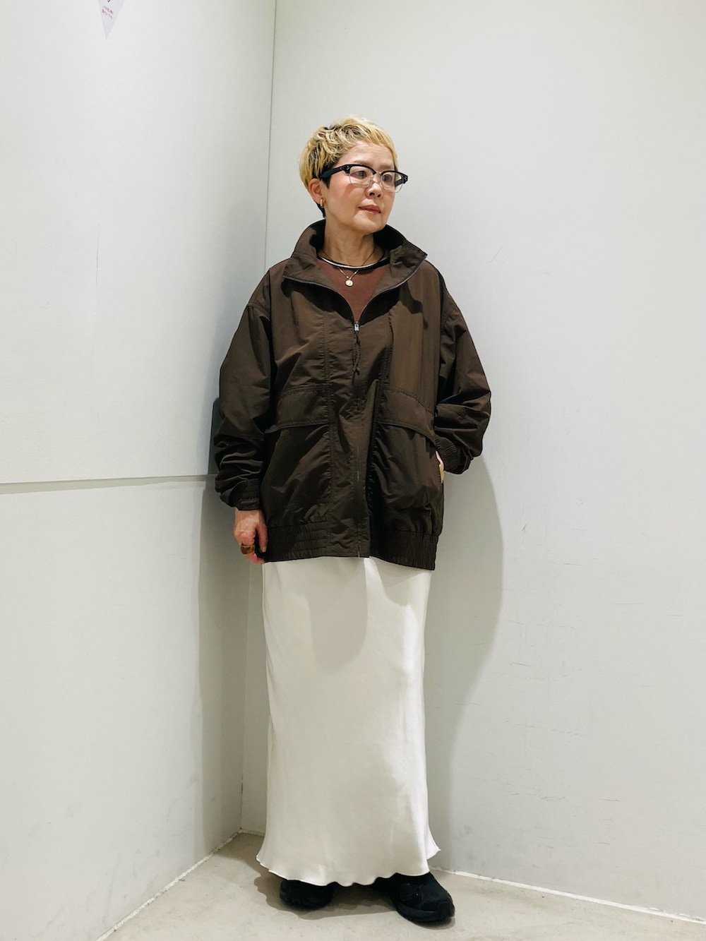 ブラック系のショルダーバッグ、ブラウン系のブルゾン、ブラウン系のTシャツ/カットソーを着用したレディースの春コーディネートの2枚目の写真