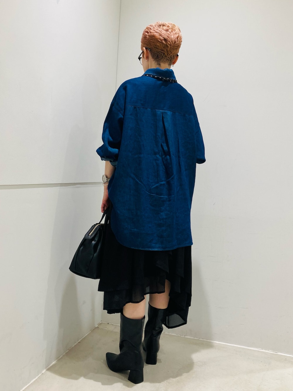 ブラック系のブーツ、ブルー系のシャツ/ブラウス、ブラック系のスカートを着用したレディースの夏コーディネートの3枚目の写真