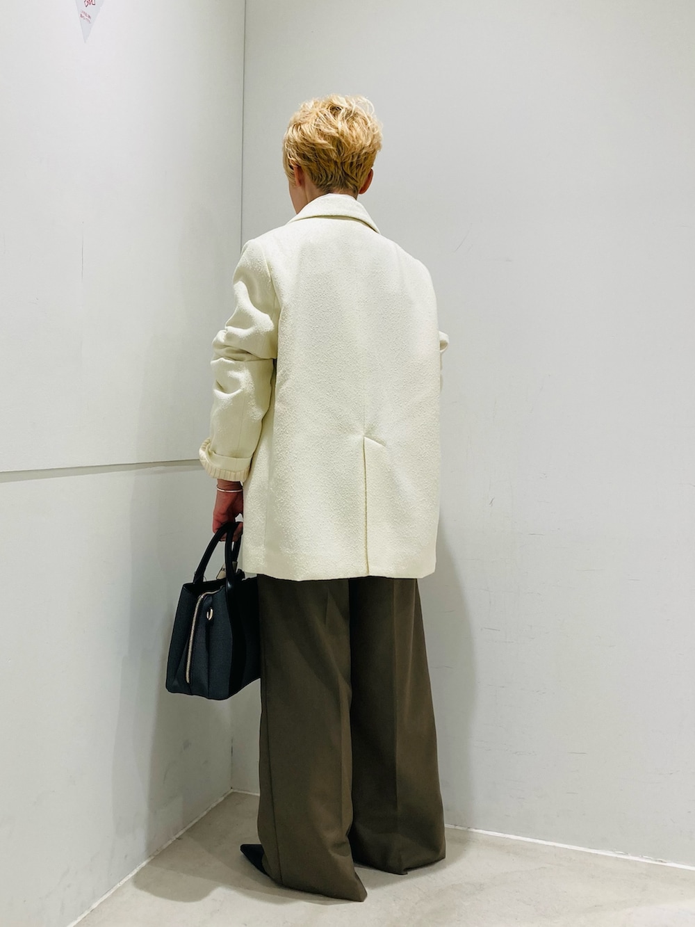 ホワイト系のテーラードジャケット、ホワイト系のシャツ/ブラウス、グリーン系のスラックスを着用したレディースの冬コーディネートの3枚目の写真