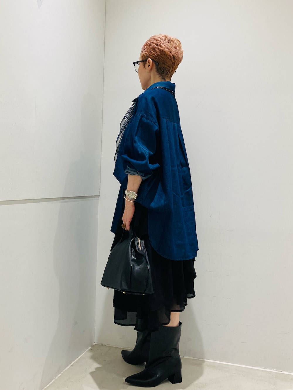 ブラック系のブーツ、ブルー系のシャツ/ブラウス、ブラック系のスカートを着用したレディースの夏コーディネートの2枚目の写真