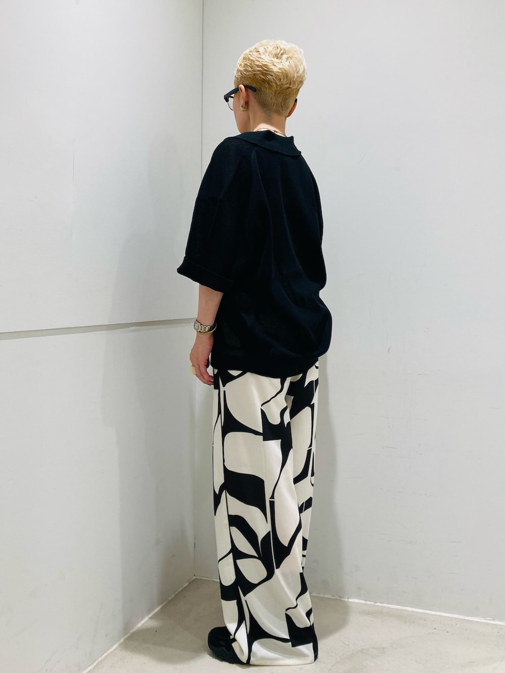 ブラック系のニット/セーター、ブラック系のその他パンツ、ホワイト系のトートバッグを着用したレディースの夏コーディネートの2枚目の写真