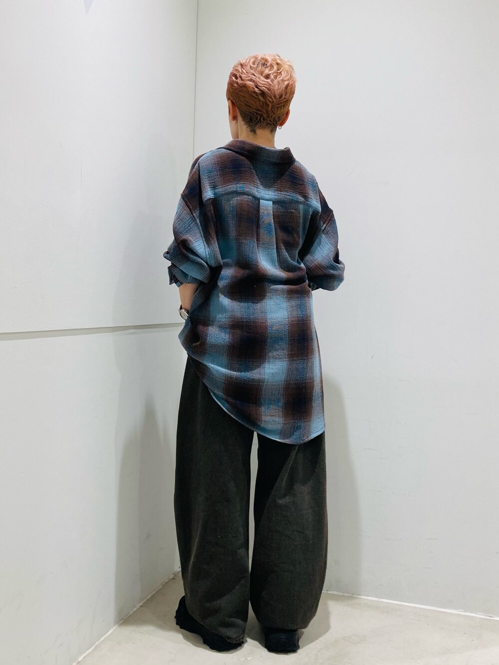 ブラウン系のデニムパンツ、ブルー系のシャツ/ブラウス、ホワイト系のキャミソールを着用したレディースの夏コーディネートの3枚目の写真