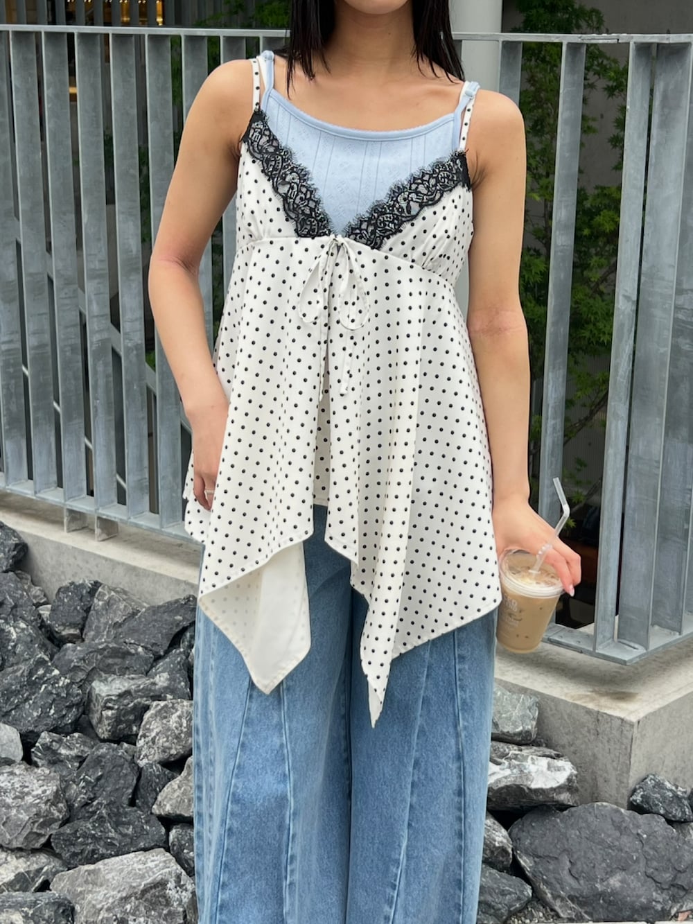 ブルー系のキャミソール、ホワイト系のトップス、ブルー系のデニムパンツを着用したレディースの春コーディネートの4枚目の写真