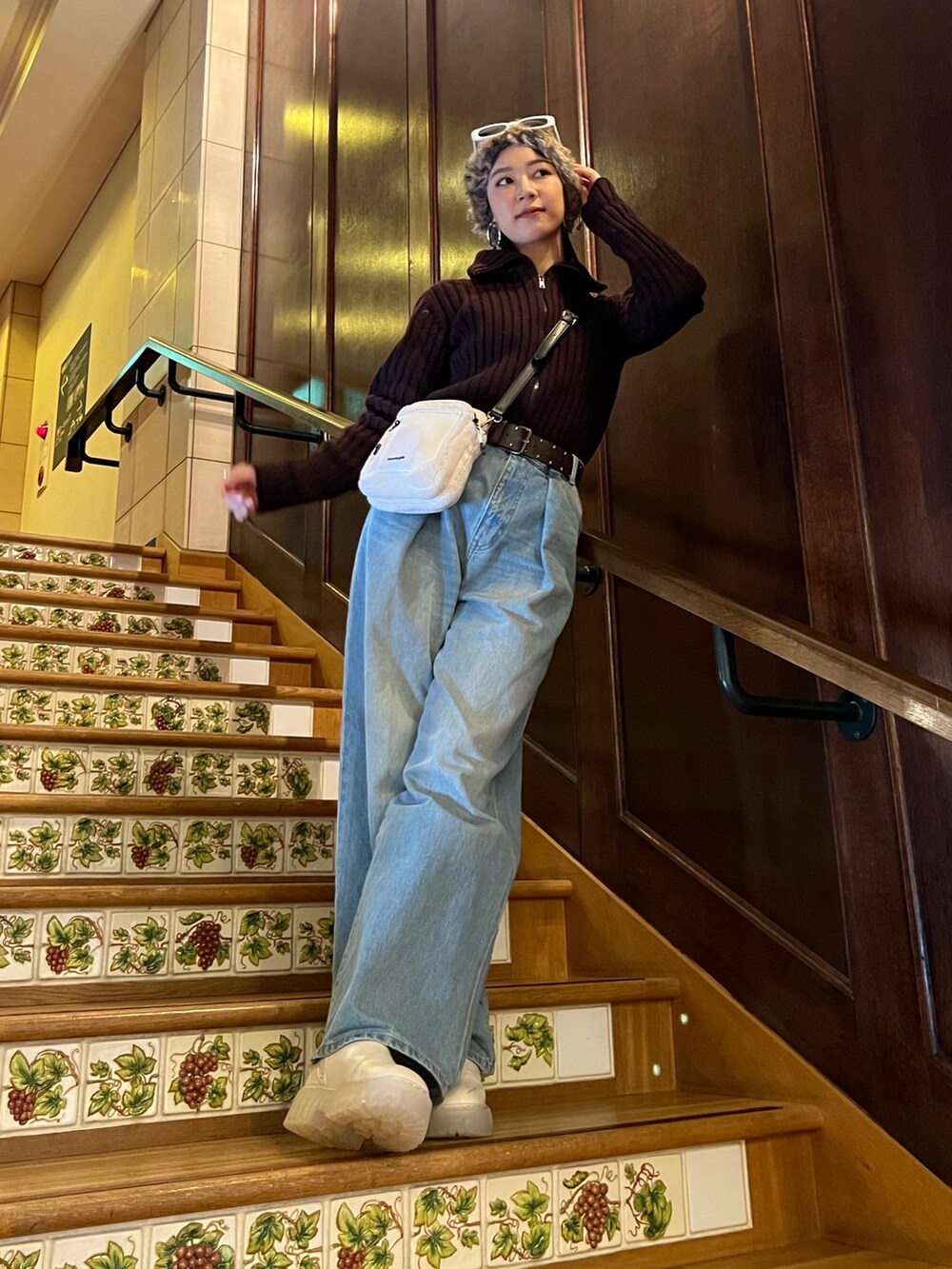 ブルー系のデニムパンツ、ホワイト系のブーツ、ホワイト系のショルダーバッグを着用したレディースの冬コーディネートの4枚目の写真