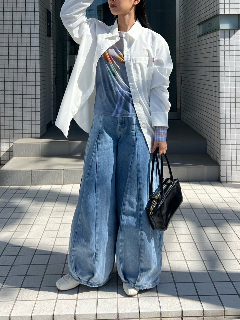 ホワイト系のシャツ/ブラウス、ブルー系のトップス、ブルー系のデニムパンツを着用したレディースの春コーディネートの5枚目の写真