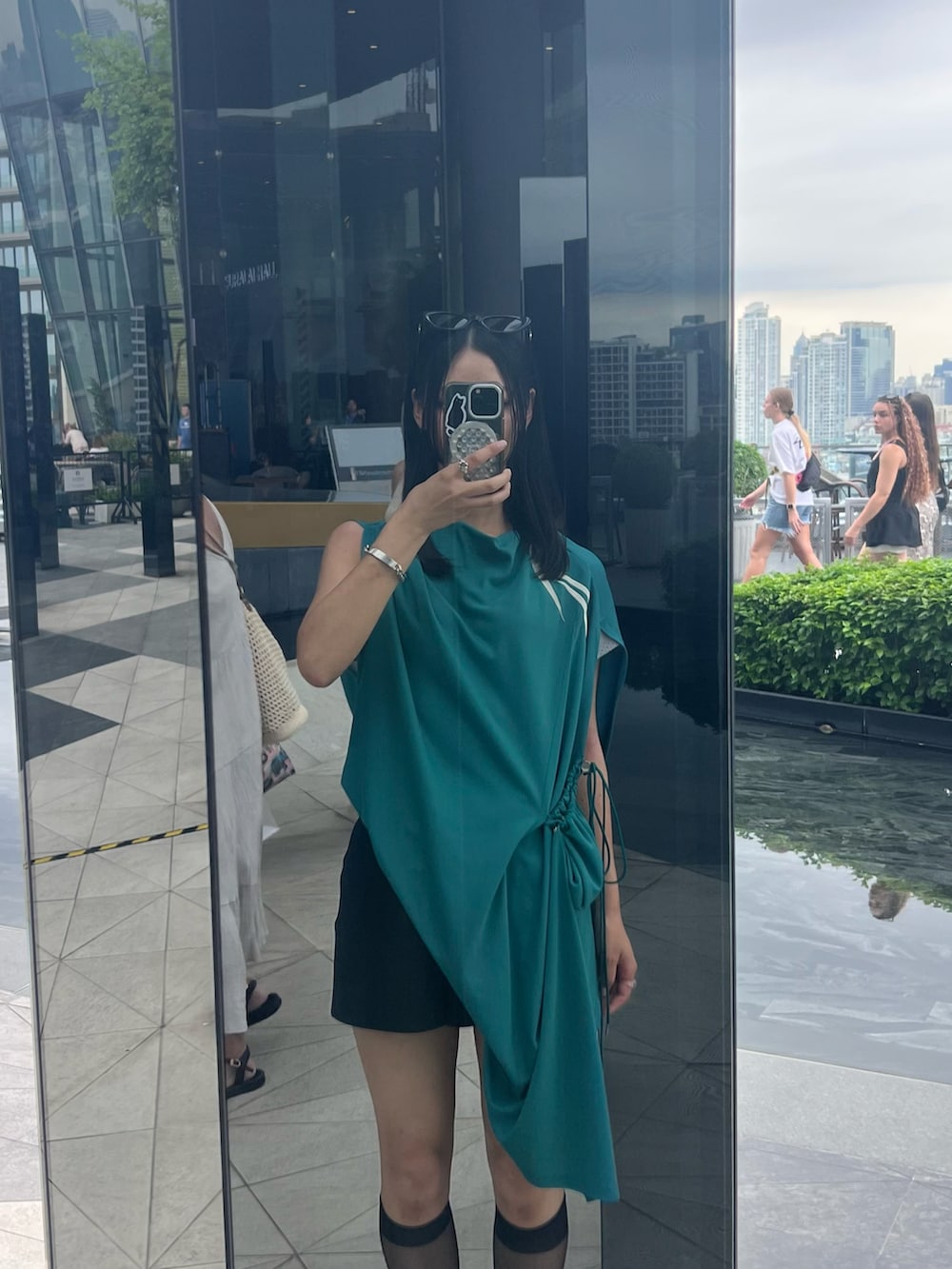 グリーン系のトップス、ブラック系のパンツ、ブラック系のシューズを着用したレディースの秋コーディネートの2枚目の写真