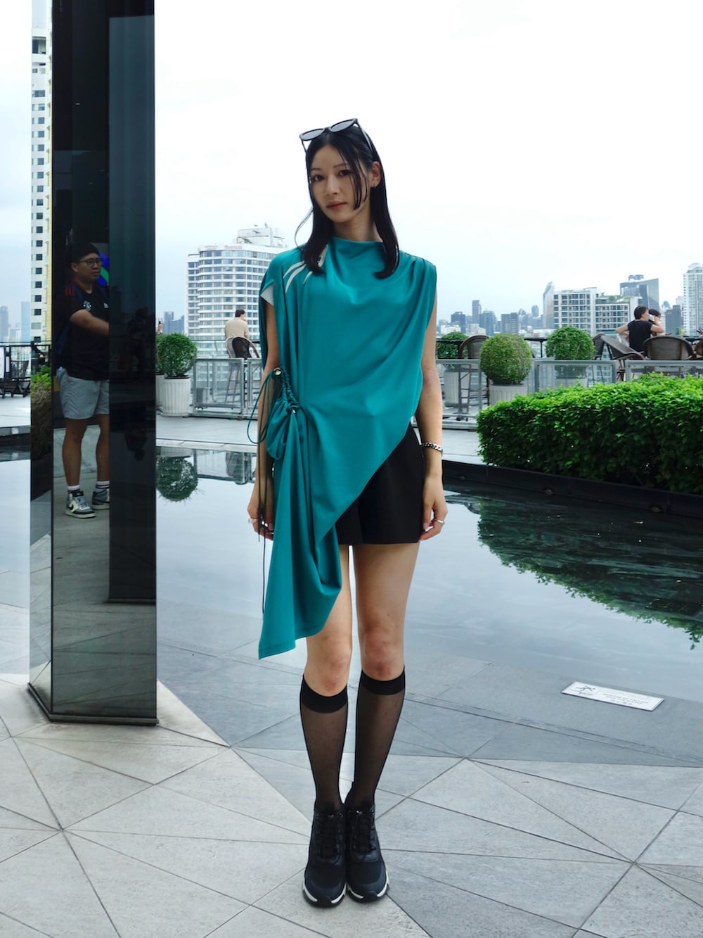 グリーン系のトップス、ブラック系のパンツ、ブラック系のシューズを着用したレディースの秋コーディネートの3枚目の写真