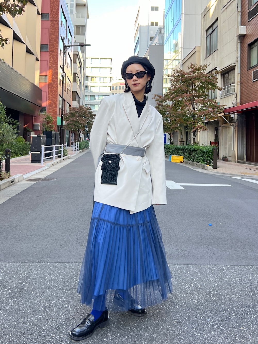 ブラック系のローファー、ブルー系のスカート、ベージュ系のテーラードジャケットを着用したレディースの冬コーディネートの3枚目の写真