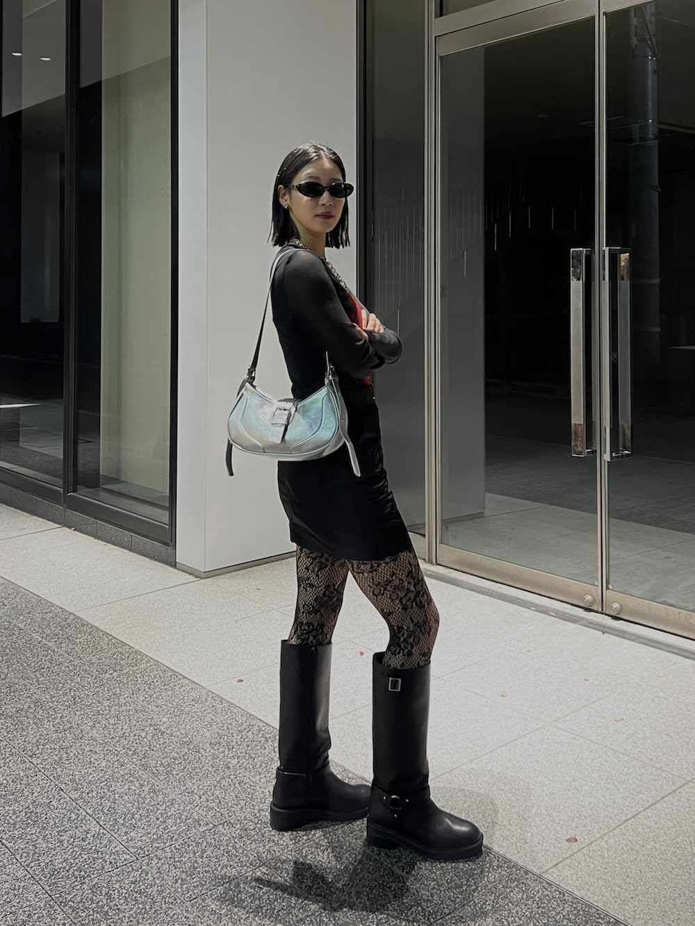 ブラック系のブーツ、ブラック系のスカート、ブラック系のトップスを着用したレディースの冬コーディネートの4枚目の写真