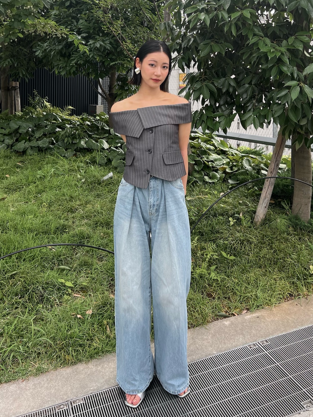 グレー系のシャツ/ブラウス、ブルー系のデニムパンツ、シルバー系のサンダルを着用したレディースの春コーディネートの2枚目の写真