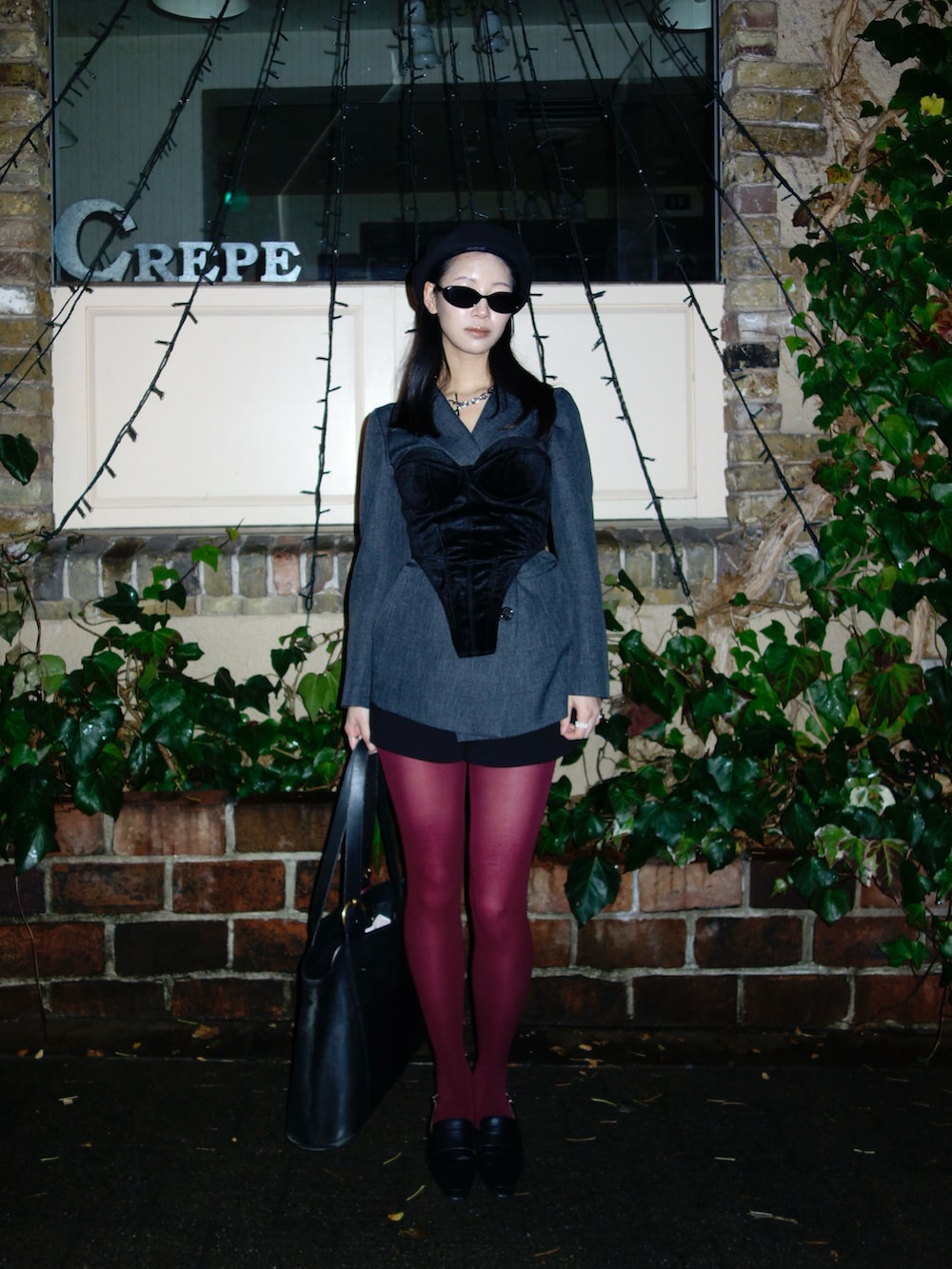 ブラック系のトップス、グレー系のテーラードジャケット、ブラック系のバッグを着用したレディースの春コーディネートの3枚目の写真