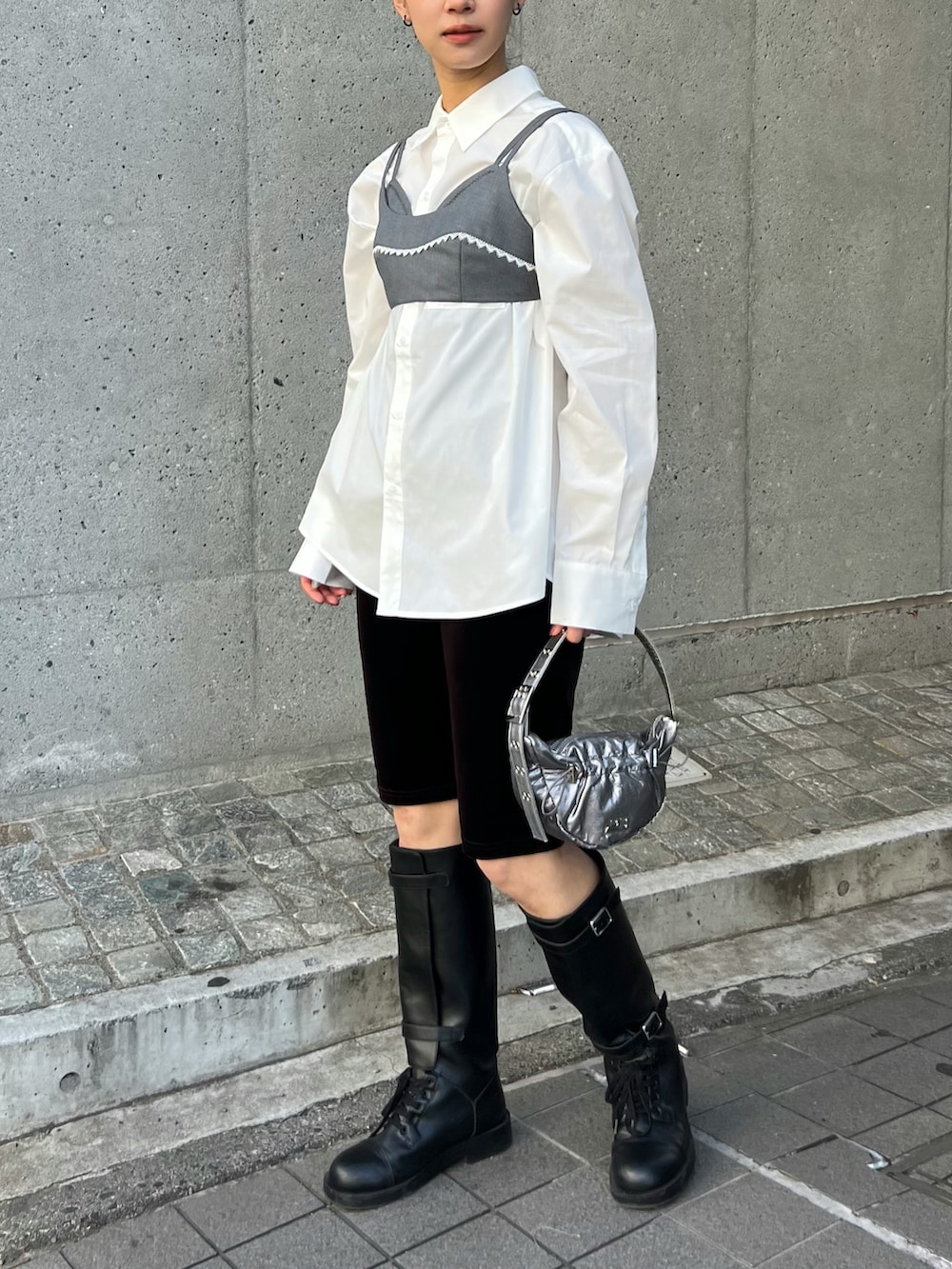 ブラック系のブーツ、ホワイト系のシャツ/ブラウス、グレー系のトップスを着用したレディースの春コーディネートの2枚目の写真