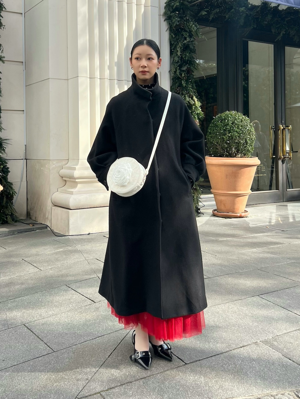 ブラック系のその他アウター、ホワイト系のバッグを着用したレディースの冬コーディネートの2枚目の写真