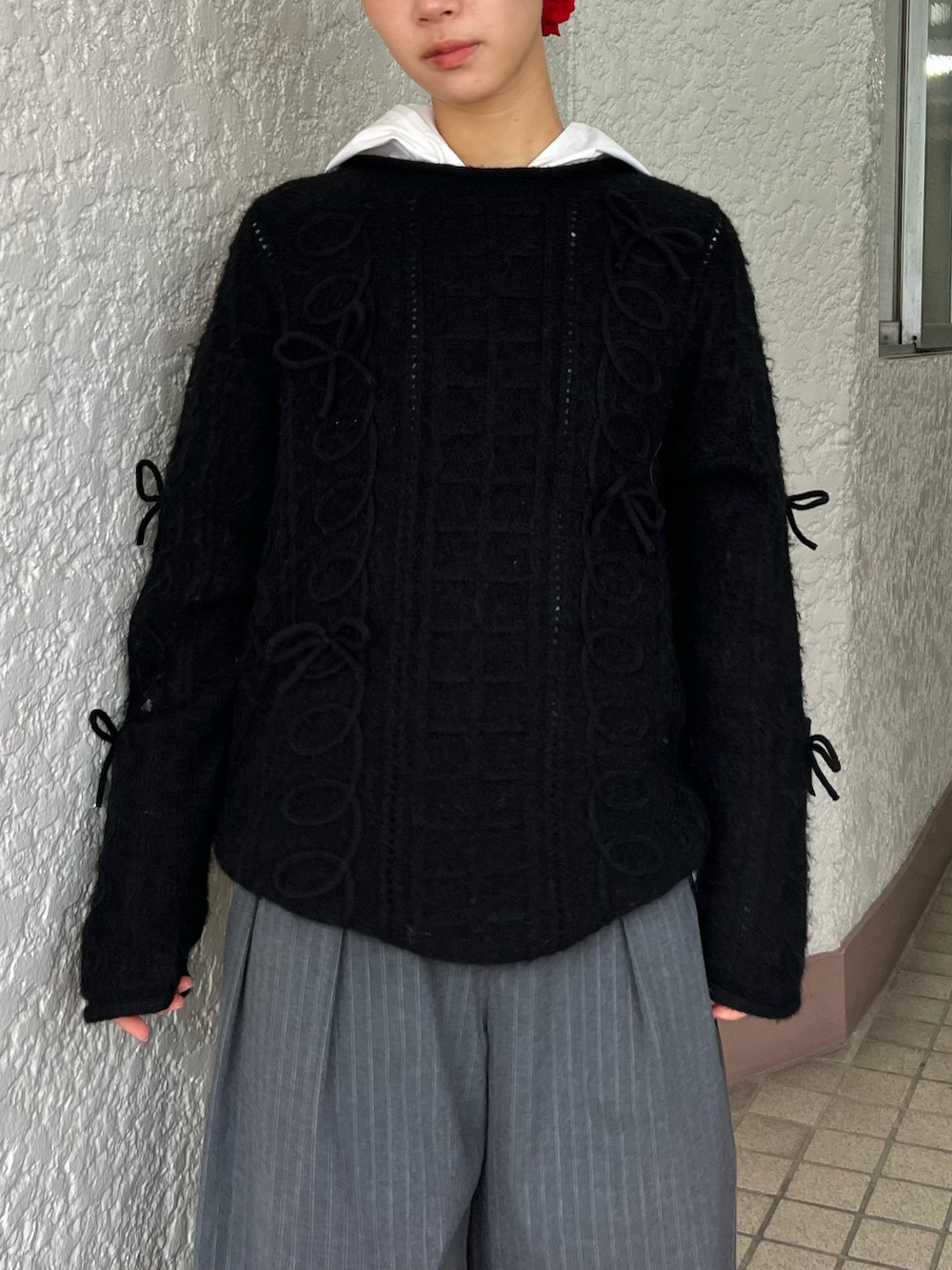 ブラック系のニット/セーター、グレー系のパンツ、レッド系のシュシュを着用したレディースの冬コーディネートの3枚目の写真