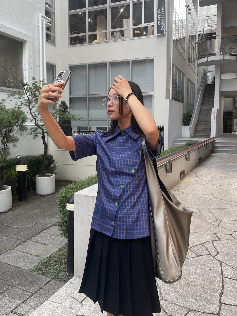 ブルー系のシャツ/ブラウス、ブラック系のスカート、ブラック系のスニーカーを着用したレディースの夏コーディネートの2枚目の写真