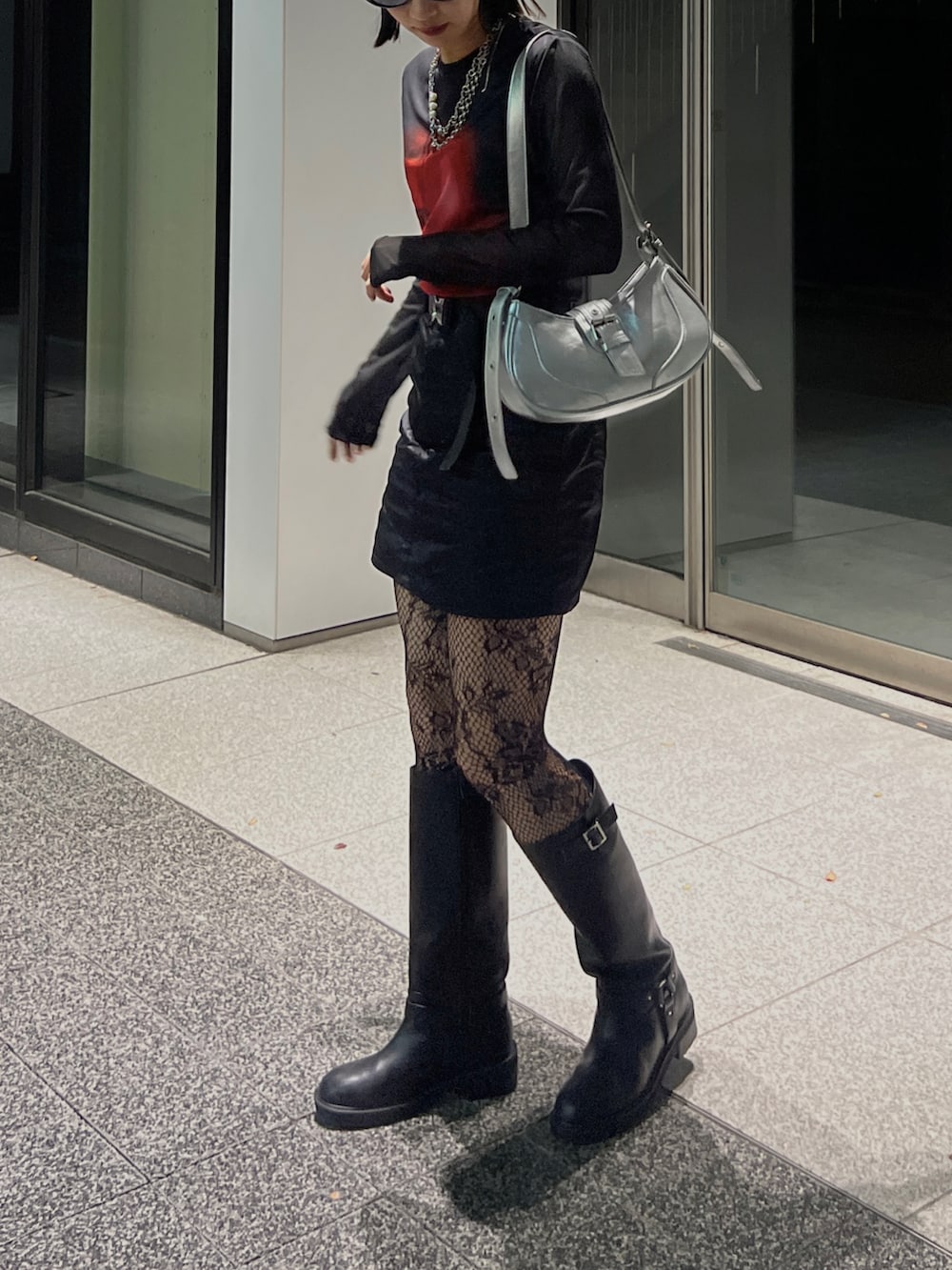 ブラック系のブーツ、ブラック系のスカート、ブラック系のトップスを着用したレディースの冬コーディネートの5枚目の写真