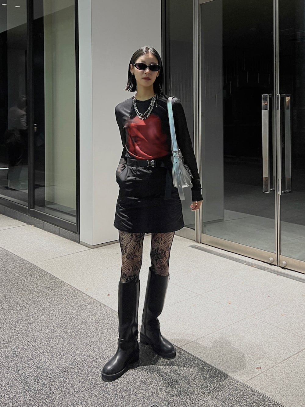 ブラック系のブーツ、ブラック系のスカート、ブラック系のトップスを着用したレディースの冬コーディネートの3枚目の写真