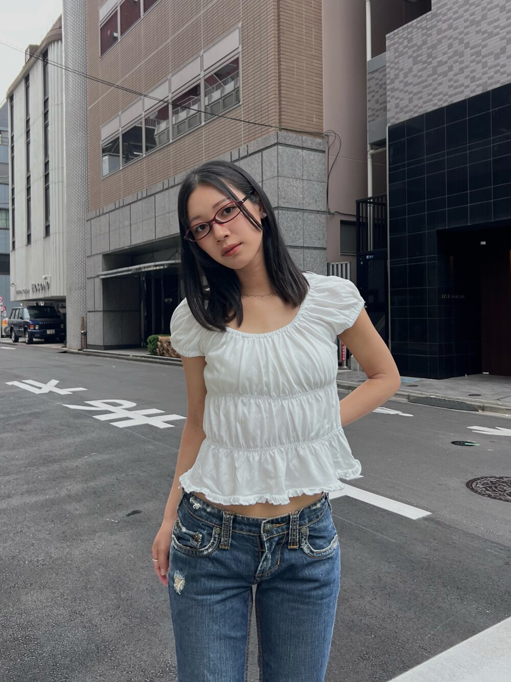 ホワイト系のTシャツ/カットソー、ブルー系のデニムパンツ、レッド系のシューズを着用したレディースの夏コーディネートの4枚目の写真