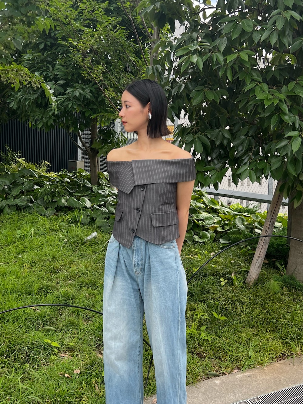 グレー系のシャツ/ブラウス、ブルー系のデニムパンツ、シルバー系のサンダルを着用したレディースの春コーディネートの3枚目の写真