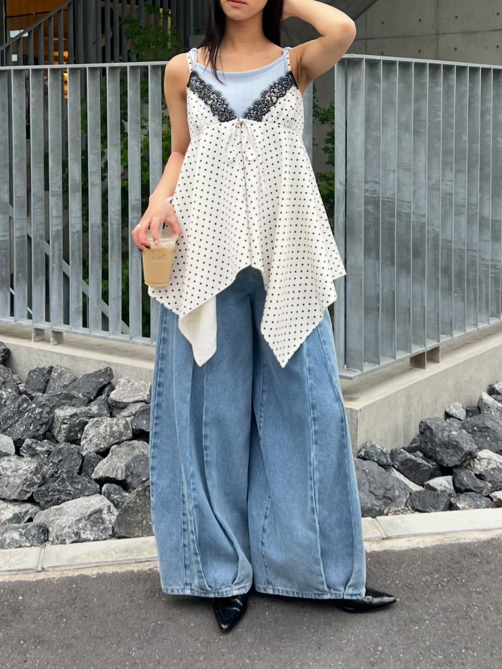 ブルー系のキャミソール、ホワイト系のトップス、ブルー系のデニムパンツを着用したレディースの春コーディネートの2枚目の写真