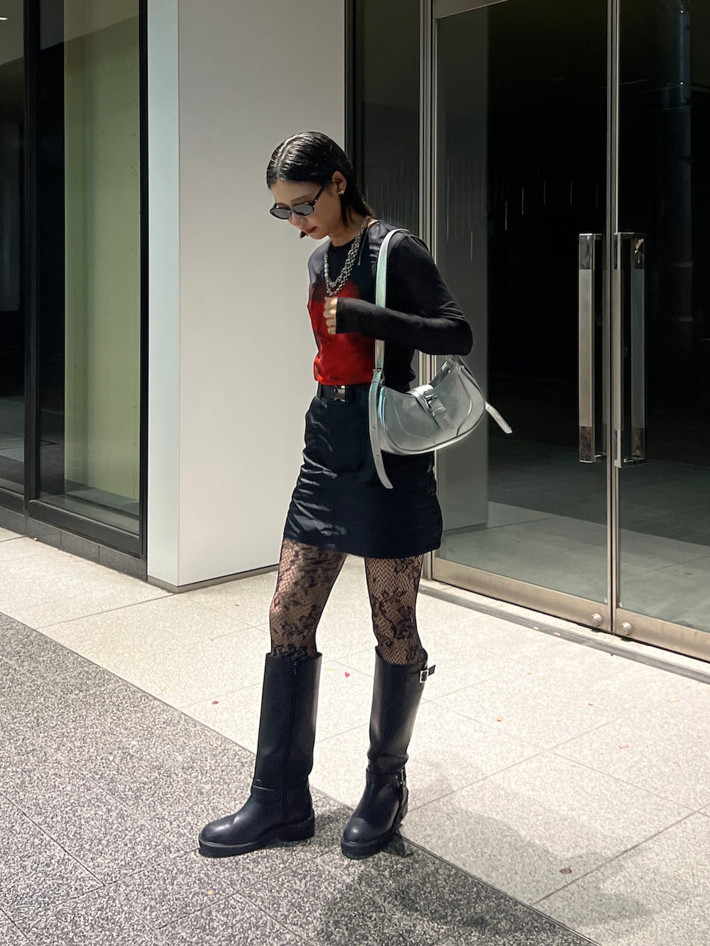 ブラック系のブーツ、ブラック系のスカート、ブラック系のトップスを着用したレディースの冬コーディネートの2枚目の写真