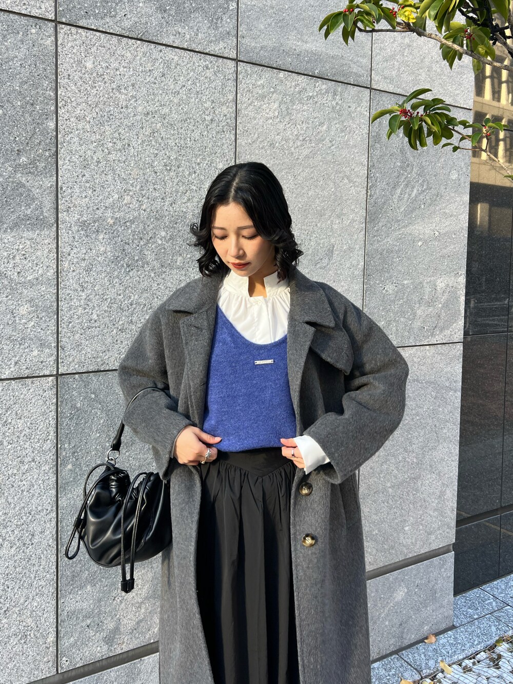 ブルー系のカーディガン/ボレロ、ブラック系のスカート、ブラック系のショルダーバッグを着用したレディースの春コーディネートの4枚目の写真
