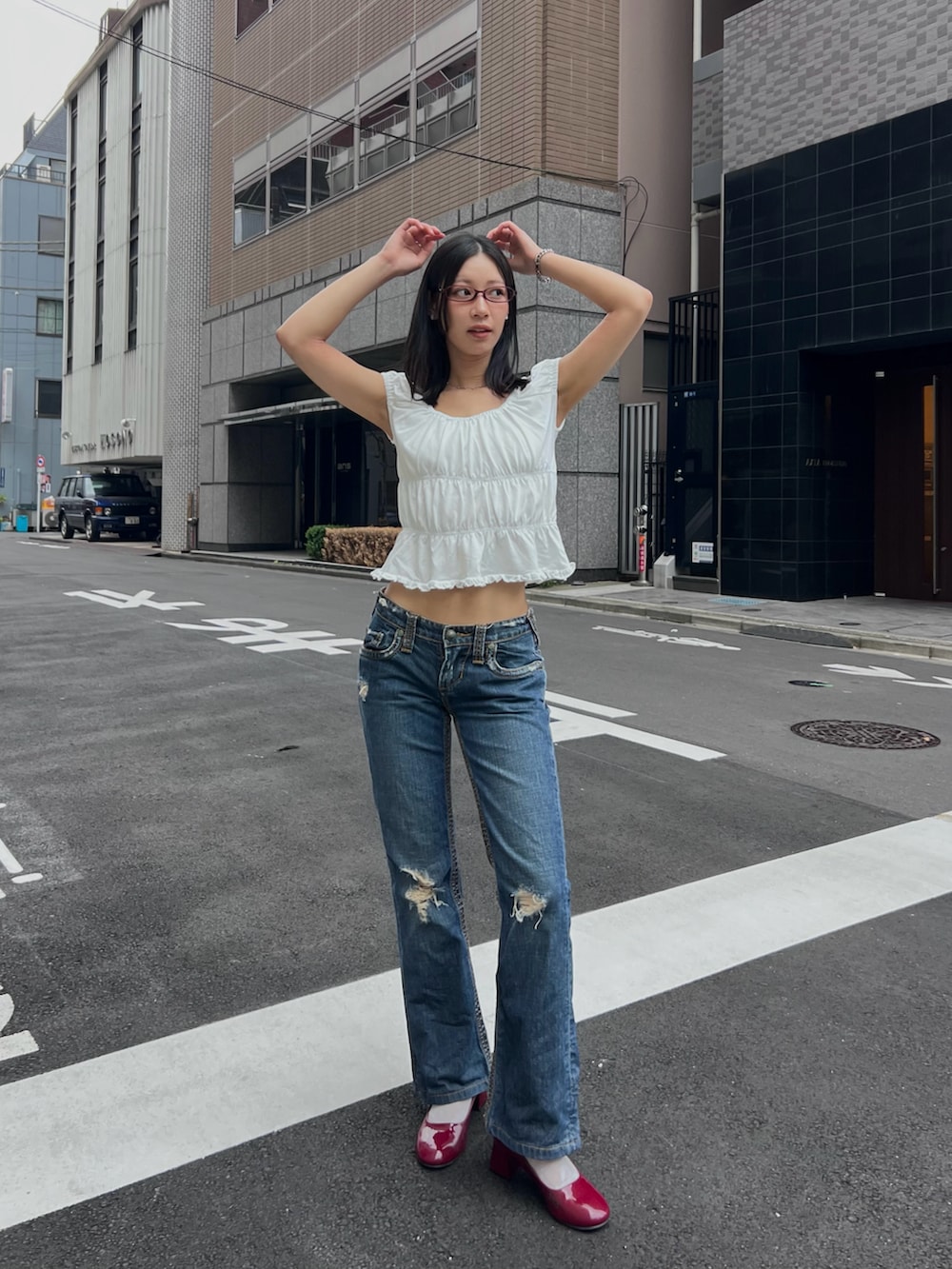 ホワイト系のTシャツ/カットソー、ブルー系のデニムパンツ、レッド系のシューズを着用したレディースの夏コーディネートの3枚目の写真