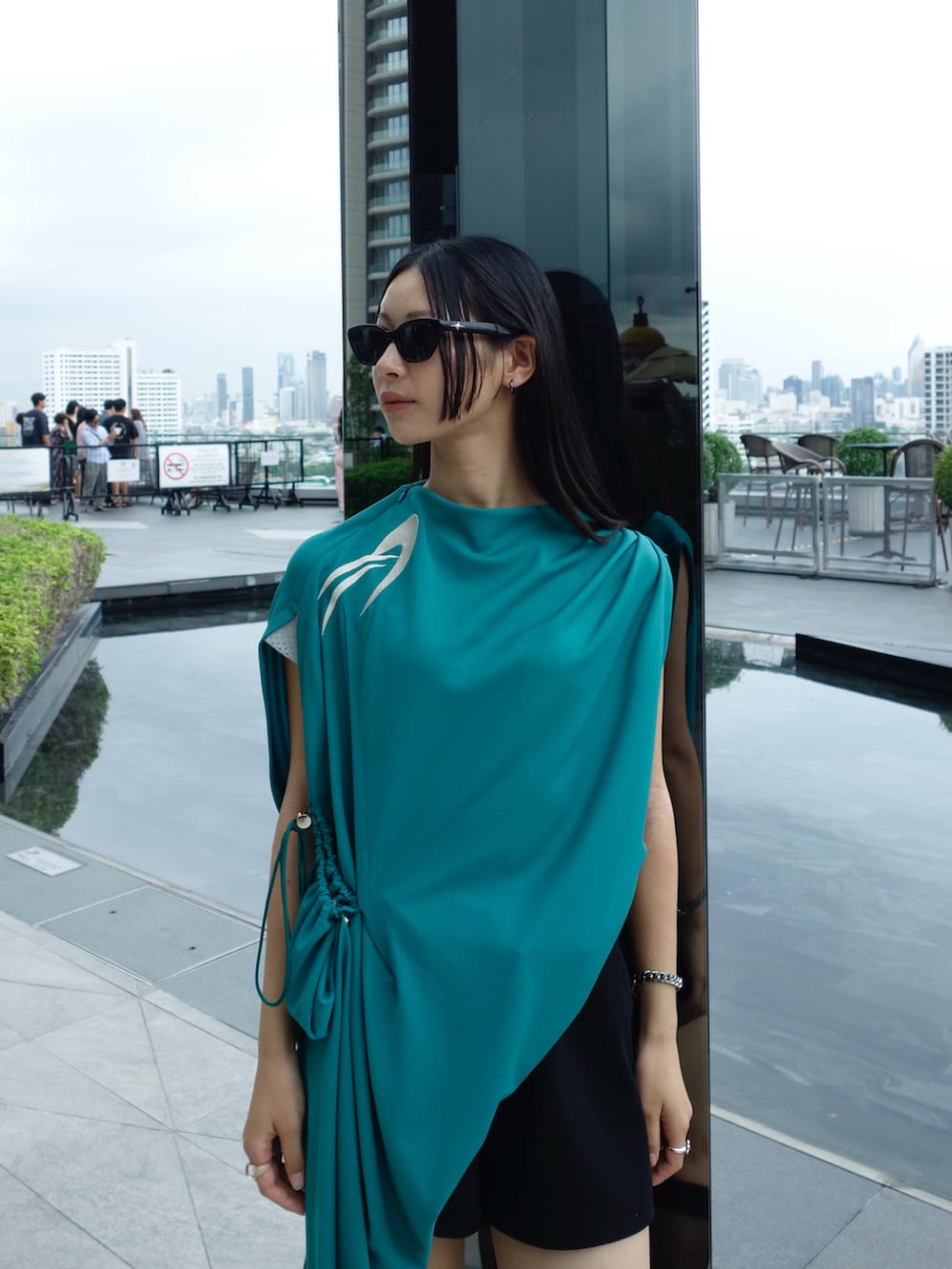 グリーン系のトップス、ブラック系のパンツ、ブラック系のシューズを着用したレディースの秋コーディネートの4枚目の写真