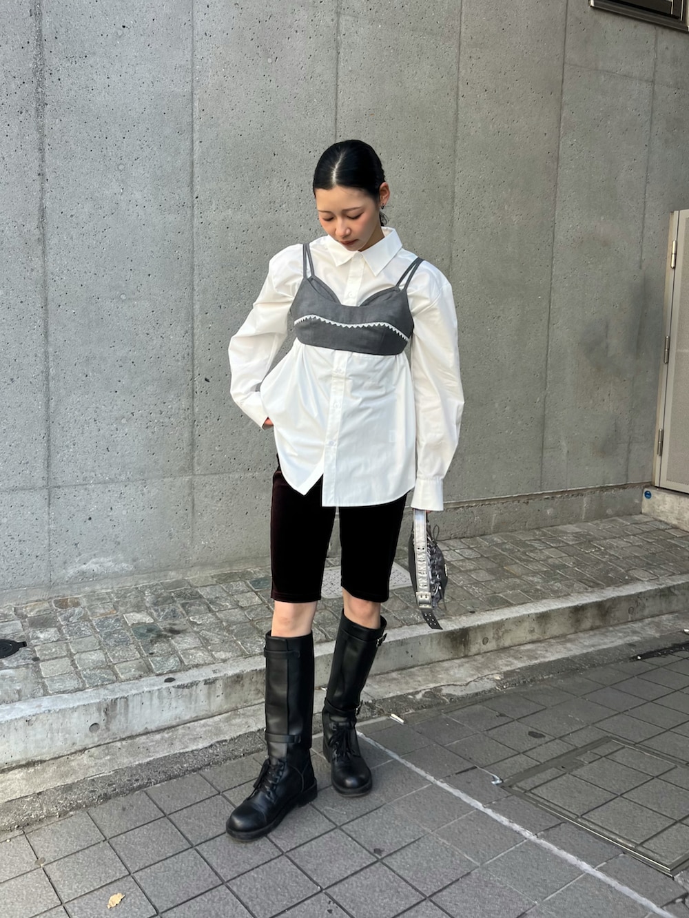 ブラック系のブーツ、ホワイト系のシャツ/ブラウス、グレー系のトップスを着用したレディースの春コーディネートの3枚目の写真