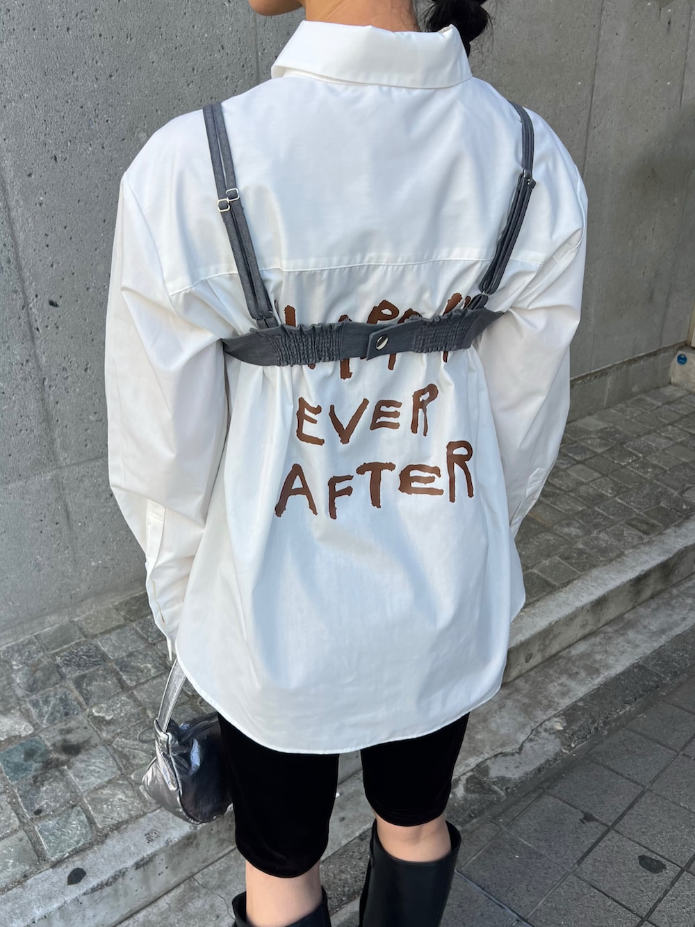 ブラック系のブーツ、ホワイト系のシャツ/ブラウス、グレー系のトップスを着用したレディースの春コーディネートの4枚目の写真