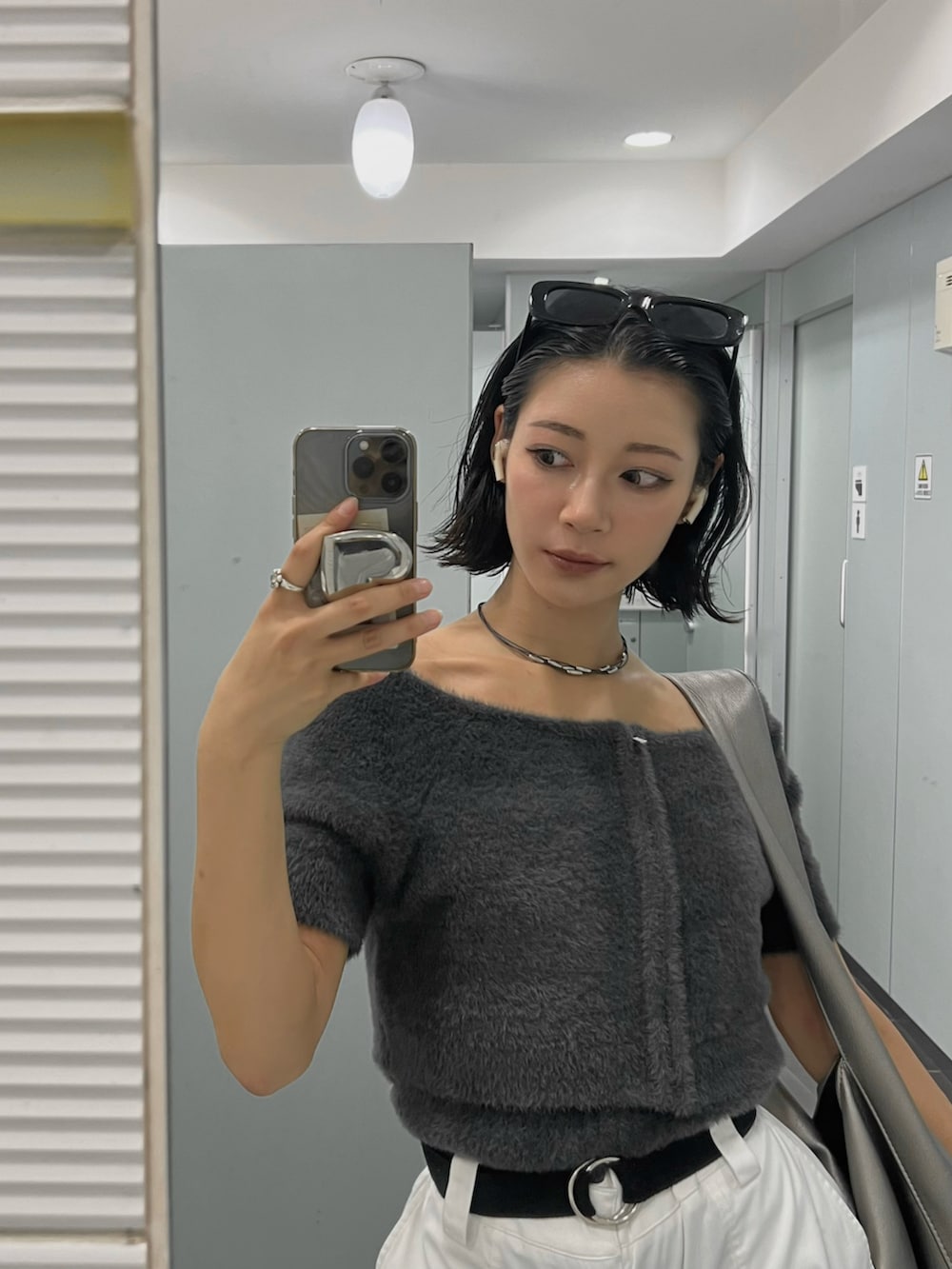 グレー系のニット/セーター、ホワイト系のカーゴパンツ、シルバー系のサンダルを着用したレディースの春コーディネートの3枚目の写真