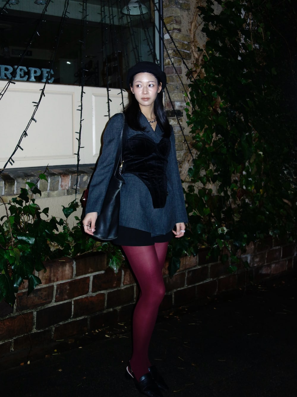 ブラック系のトップス、グレー系のテーラードジャケット、ブラック系のバッグを着用したレディースの春コーディネートの2枚目の写真