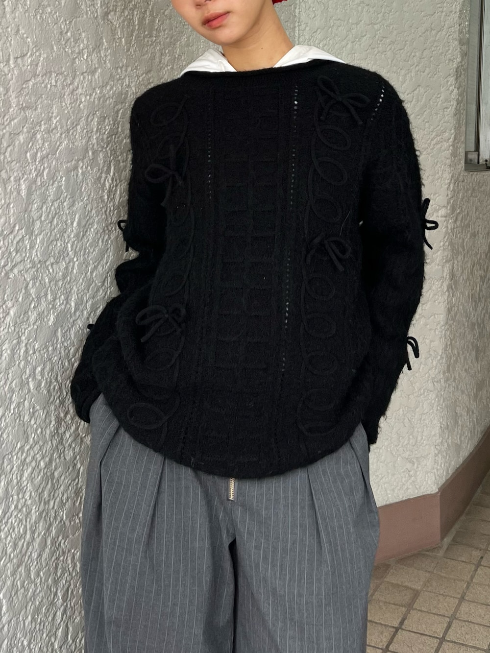 ブラック系のニット/セーター、グレー系のパンツ、レッド系のシュシュを着用したレディースの冬コーディネートの4枚目の写真