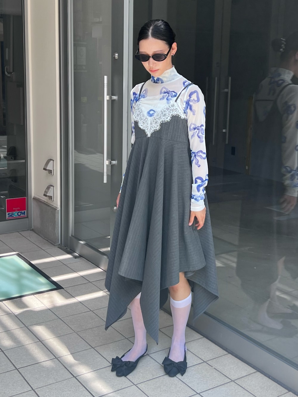 ブルー系のトップス、グレー系のワンピース/ドレス、ブラック系のサングラスを着用したレディースの秋コーディネートの2枚目の写真