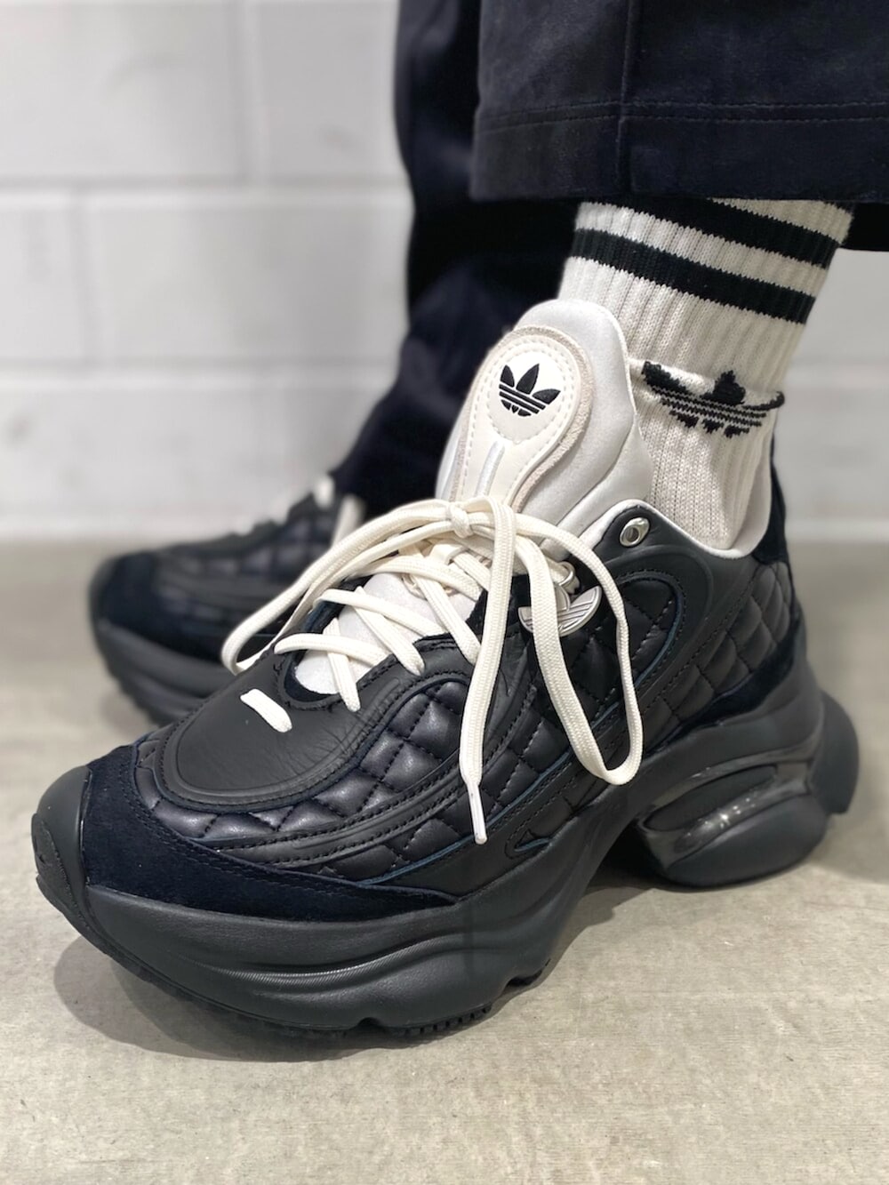 ブラック系のニット/セーター、ブラック系のスウェットパンツ、ブラック系のスニーカーを着用したメンズの秋コーディネートの6枚目の写真