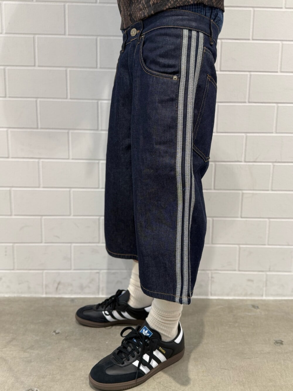 ブルー系のデニムパンツ、ブラウン系のトップス、ブラック系のシューズを着用したメンズの夏コーディネートの5枚目の写真