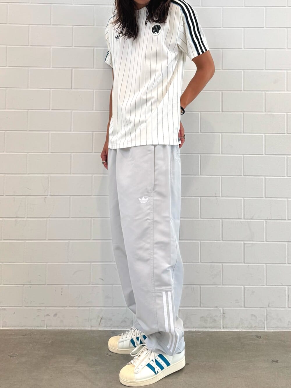 ホワイト系のTシャツ/カットソー、ホワイト系のスニーカー、ブラック系のニットキャップ/ビーニーを着用したメンズの秋コーディネートの2枚目の写真