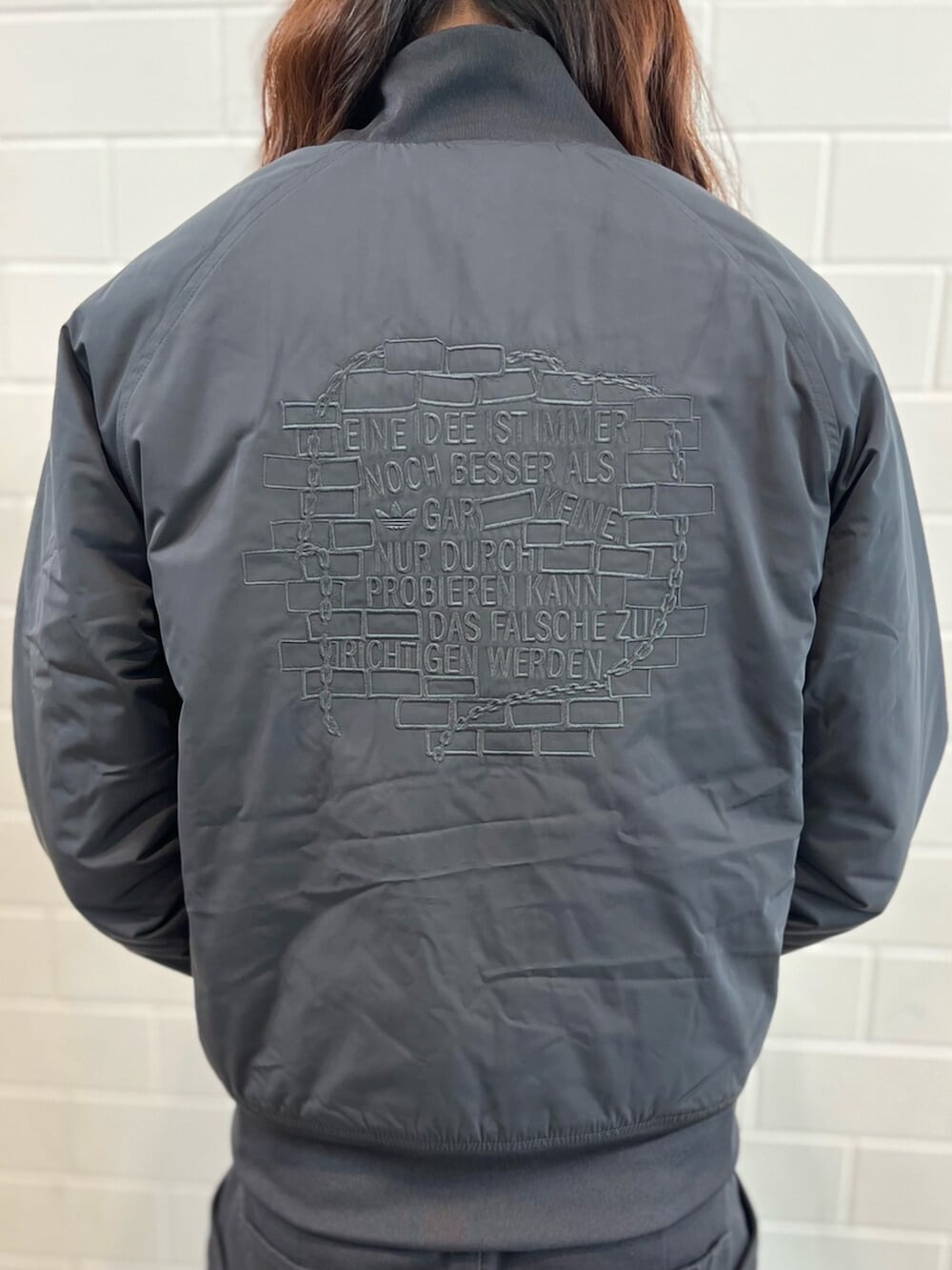 ブラック系のブルゾン、ブラック系のスニーカーを着用したメンズの秋コーディネートの5枚目の写真