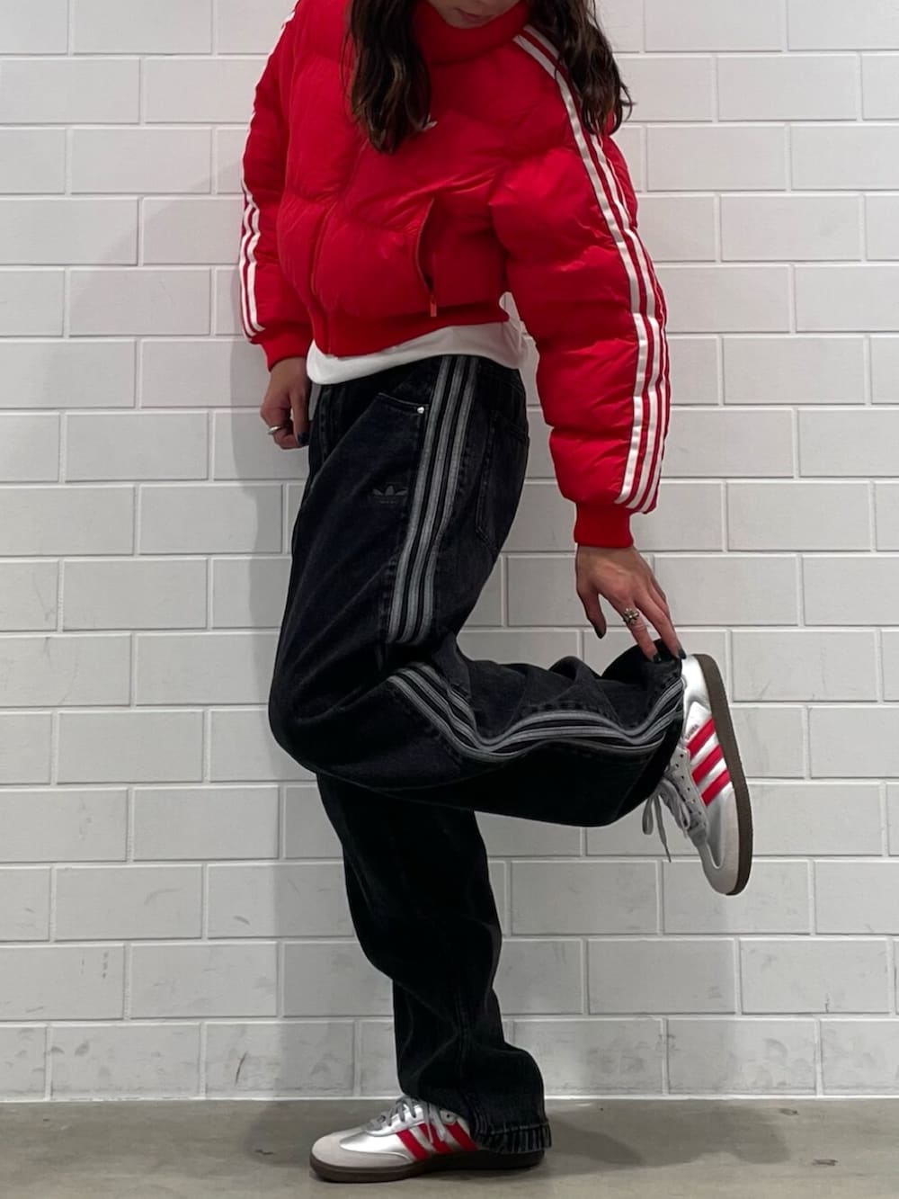 ブラック系のデニムパンツ、シルバー系のシューズ、レッド系のダウンジャケット/コートを着用したメンズの秋コーディネートの2枚目の写真